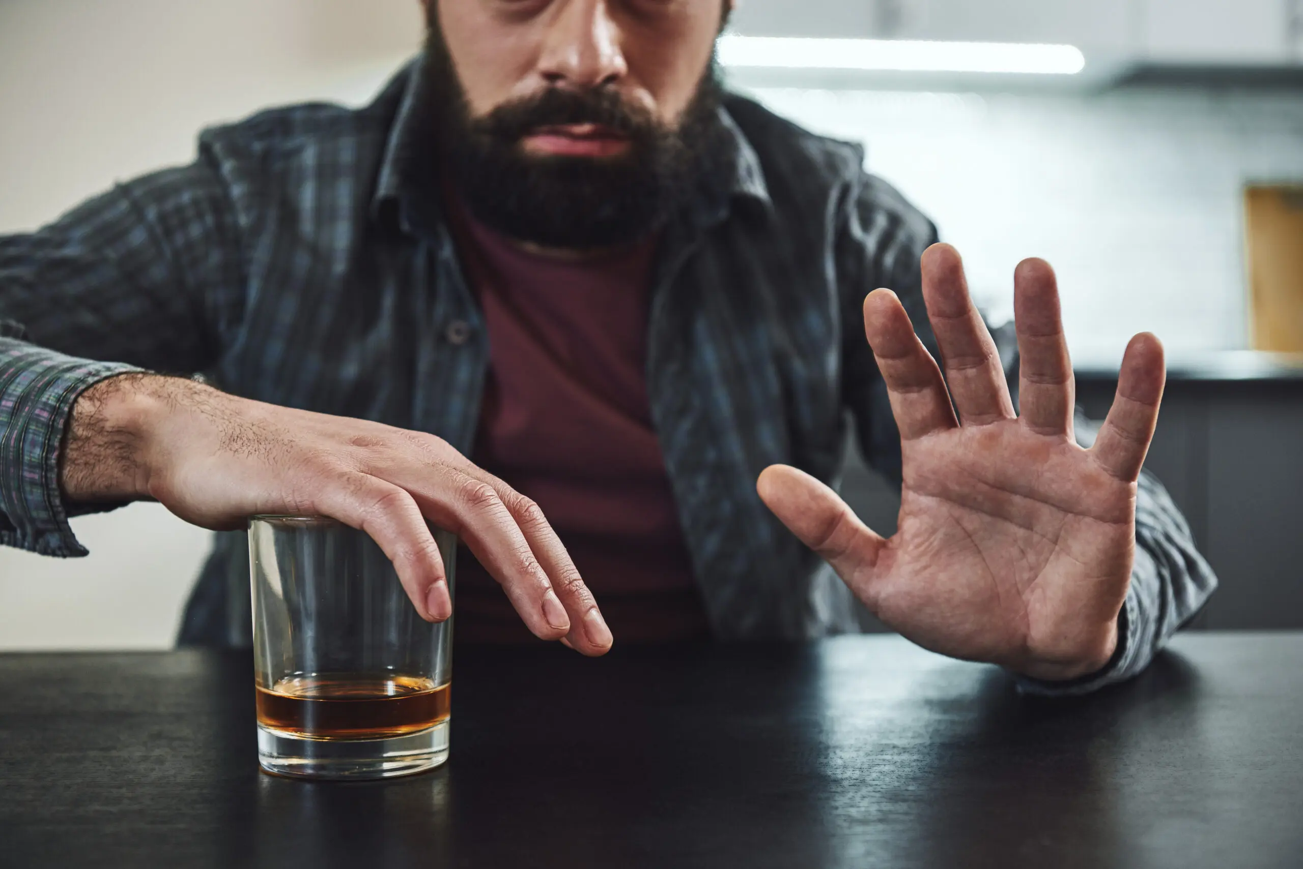 Man covering glass of alcohol. Just say no to reem the benefits of a sober life.